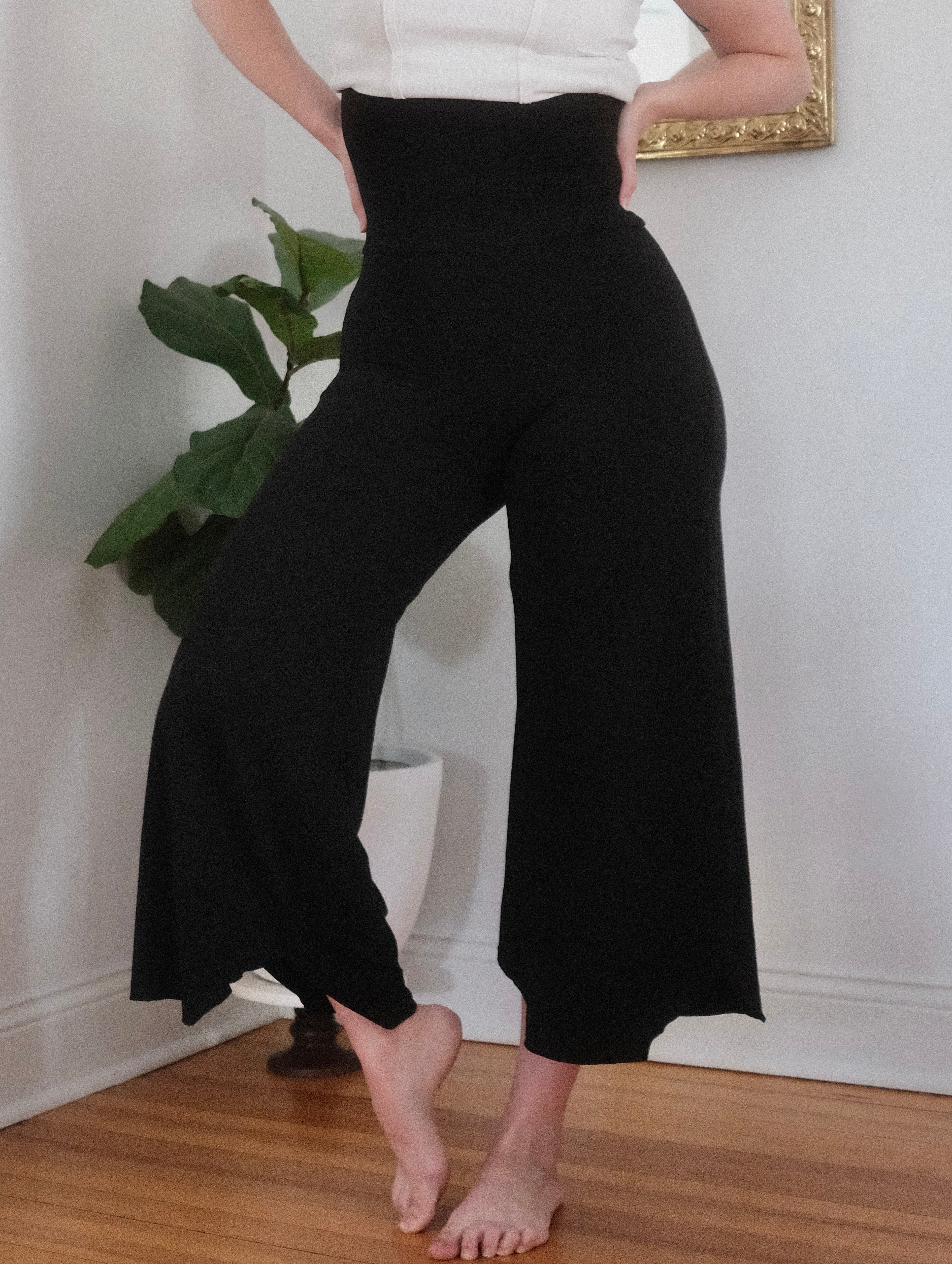 Waist down view of a female modeling black Flow Pants