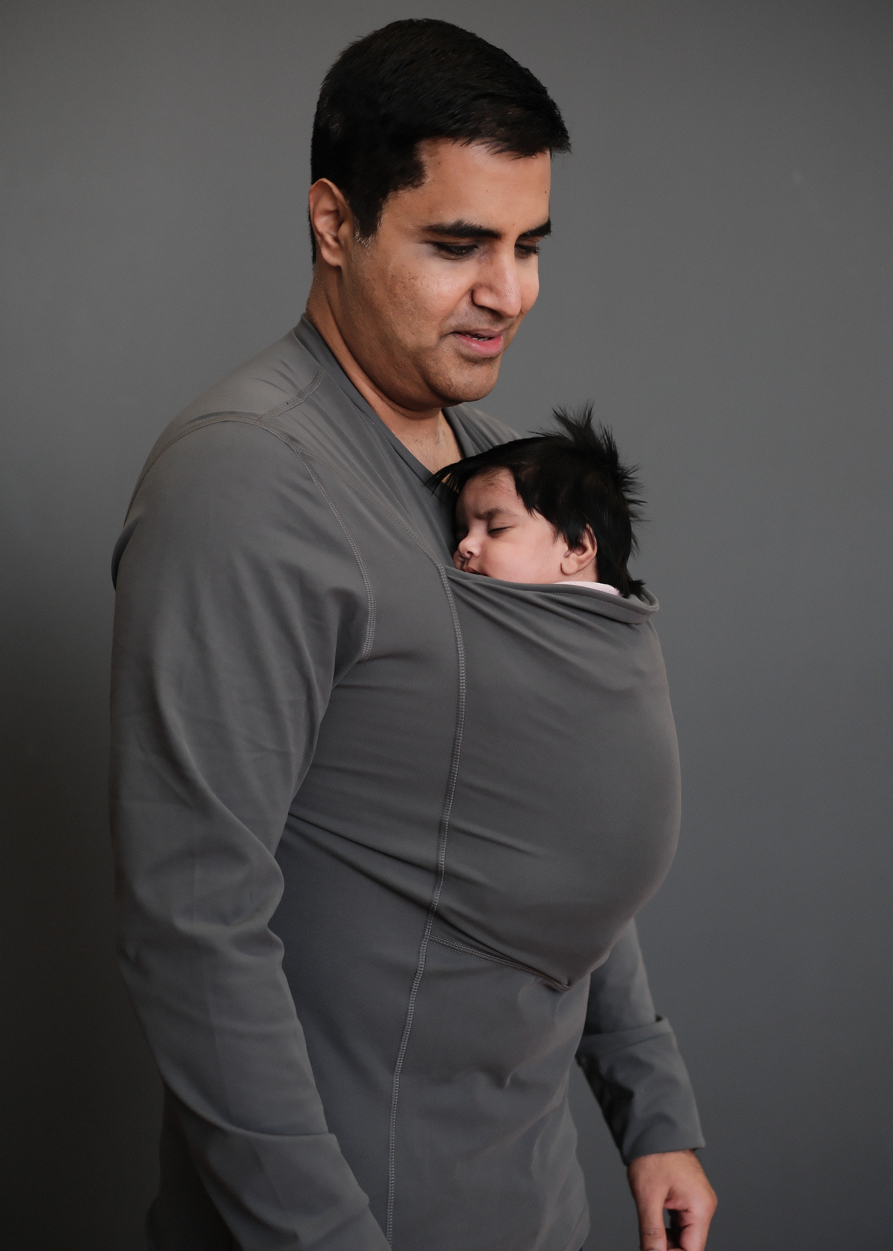 Dad wearing his newborn in the pouch of his Long Sleeve Gray Dad Shirt.