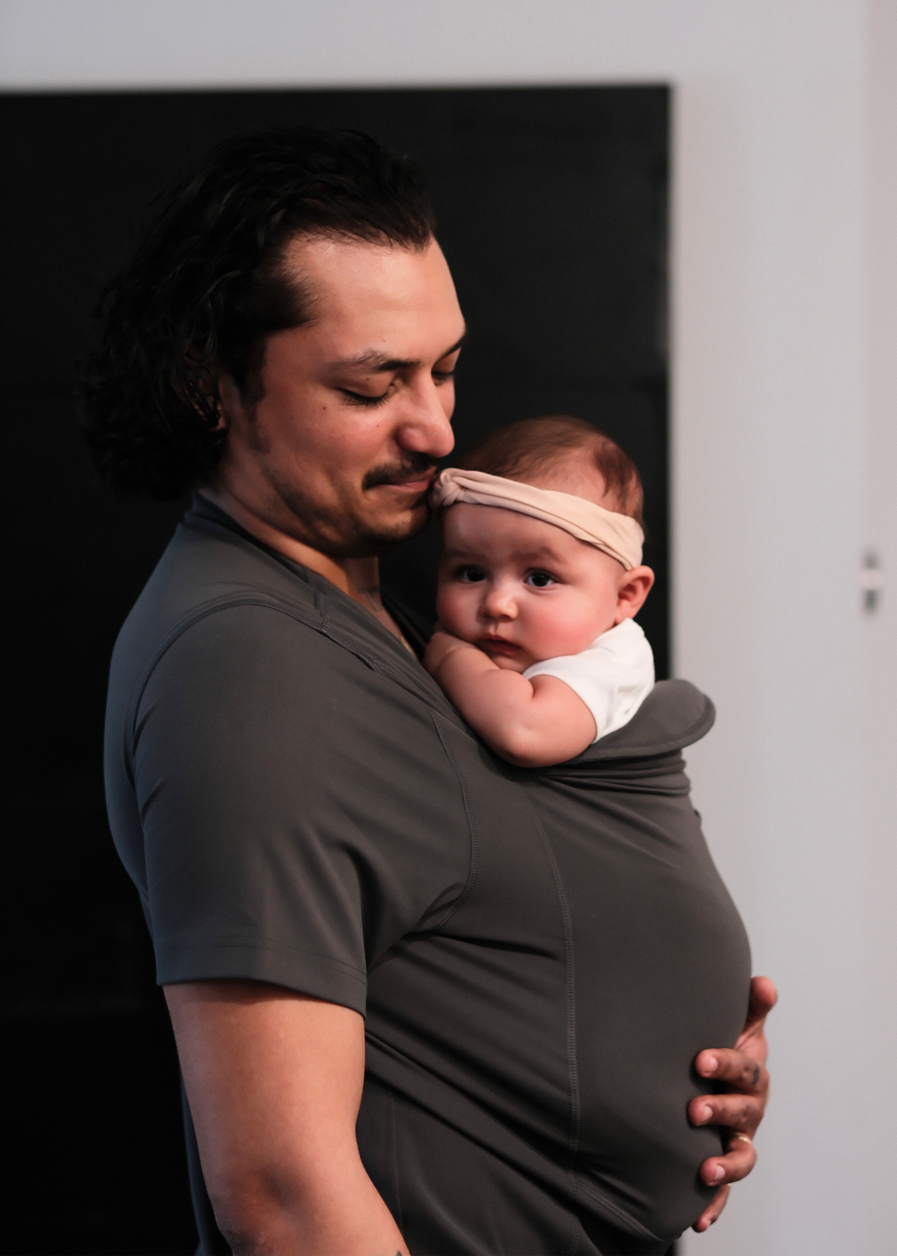 Side view of a dad wearing his baby in the pouch of his Gray Dad Shirt.