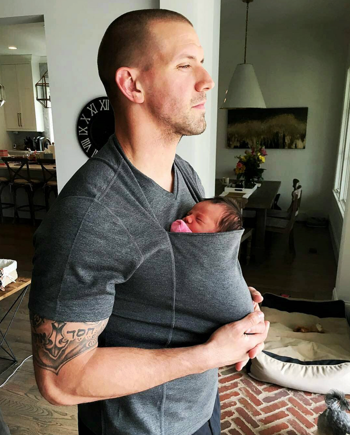 Dad wearing his newborn in a Dad Shirt at home