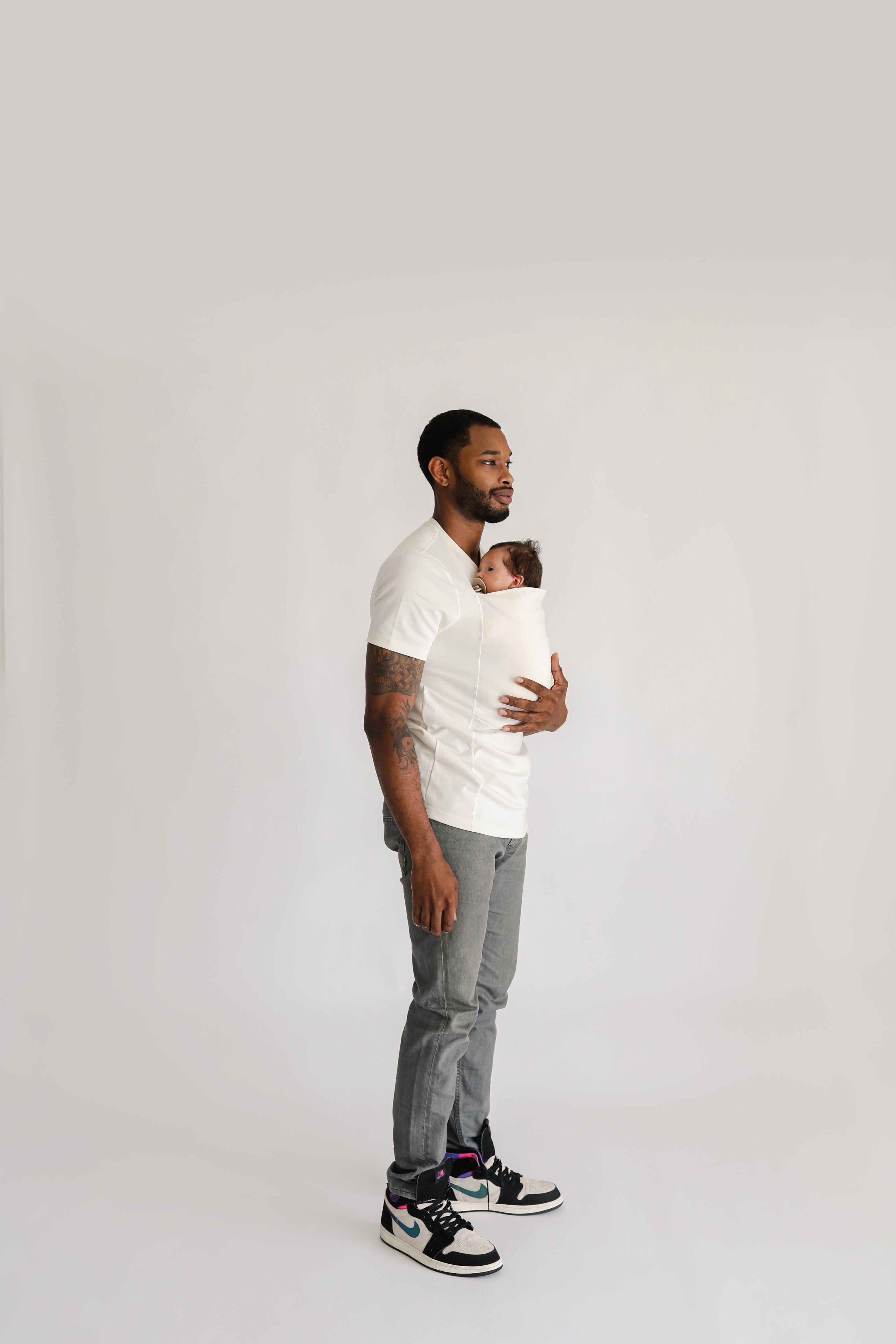 Side profile of a dad wearing a newborn in a natural Dad Shirt.