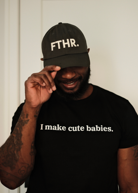 Dad wearing a charcoal cap with 'FTHR.' and a black t-shirt with 'I make cute babies.' text.