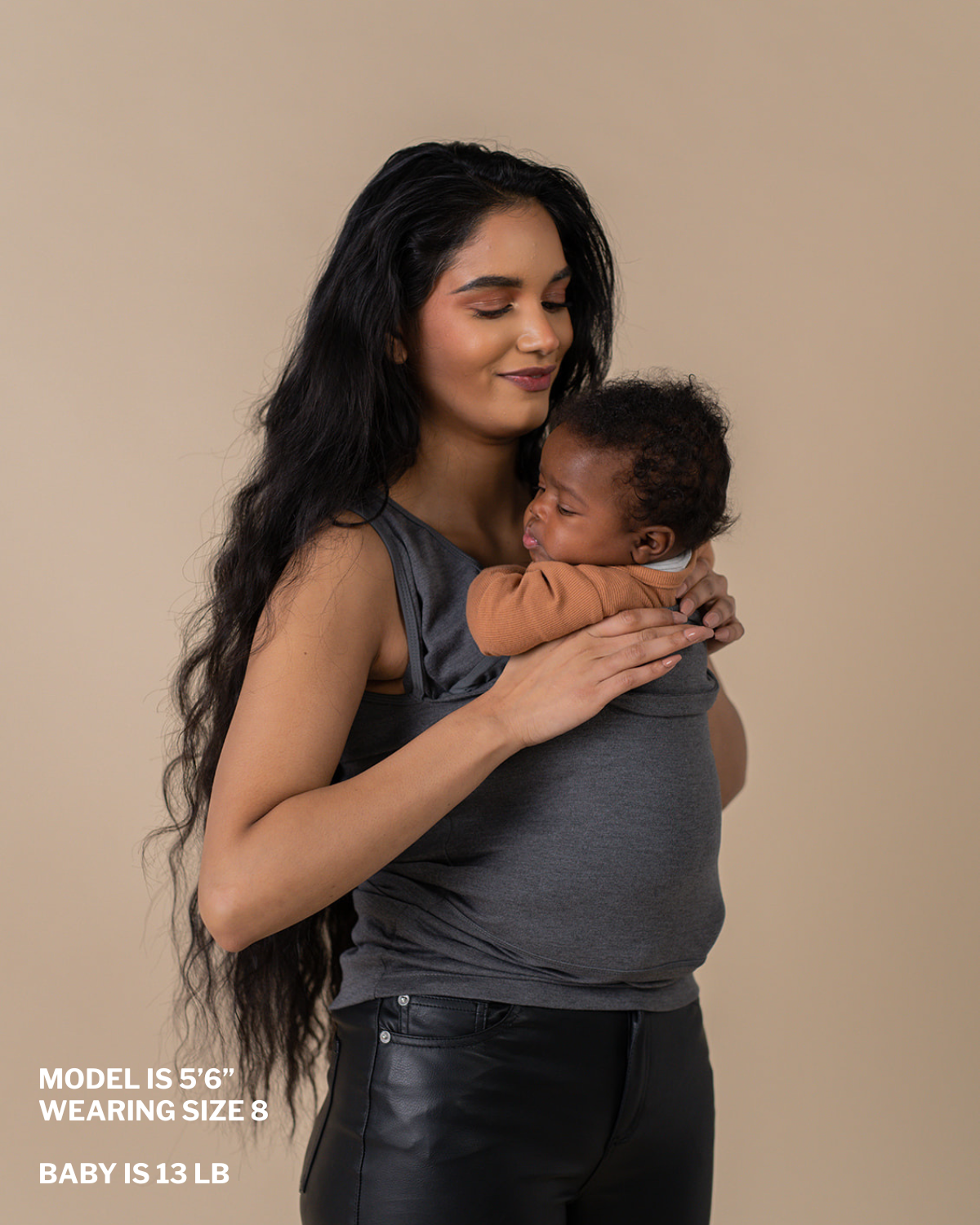 Mom demonstrating removing baby from pouch. "Model is 5 ft 6 in, wearing size 8, baby is 13 lbs"