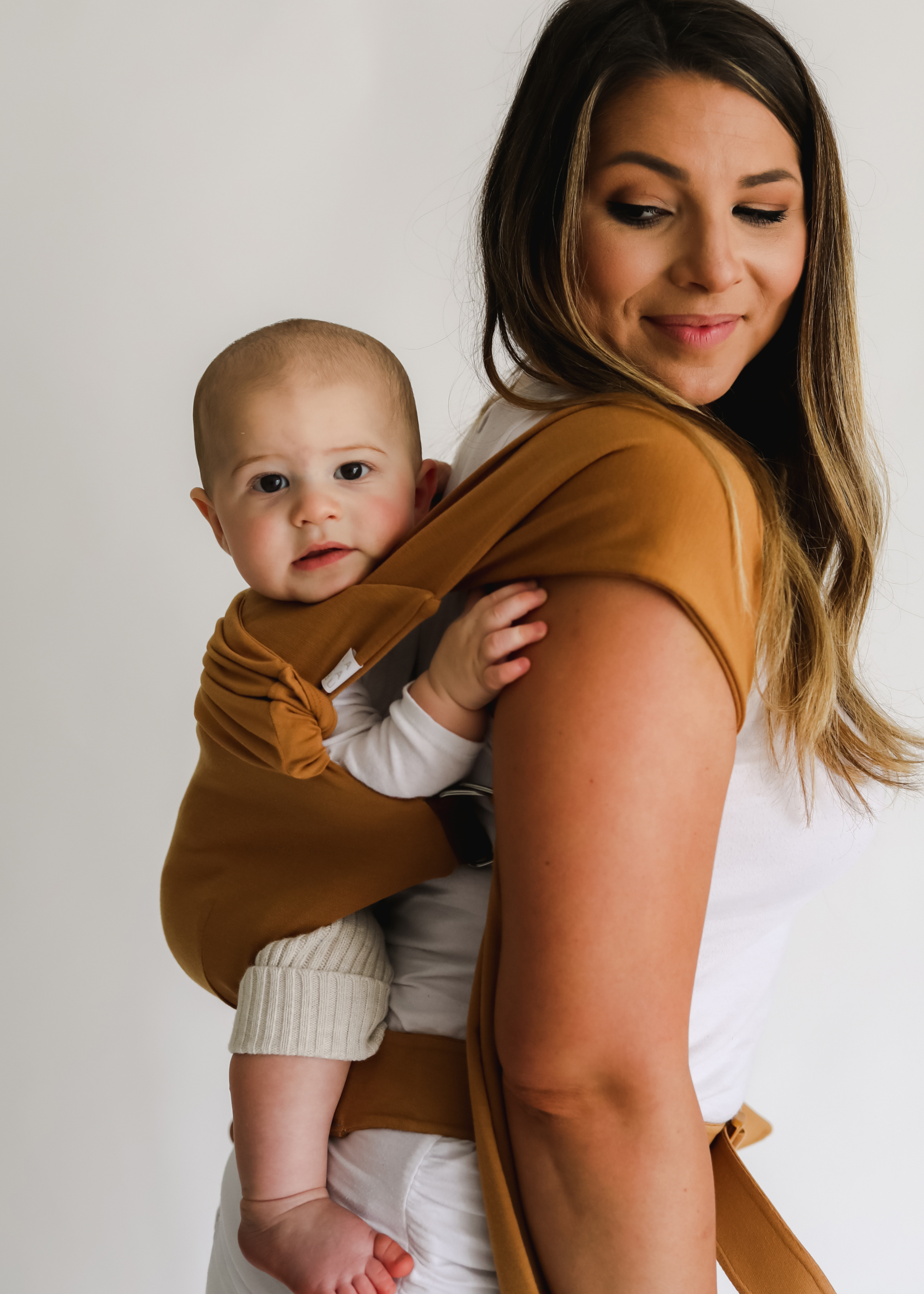 Mom back carrying her baby in a Camel Simple Wrap.