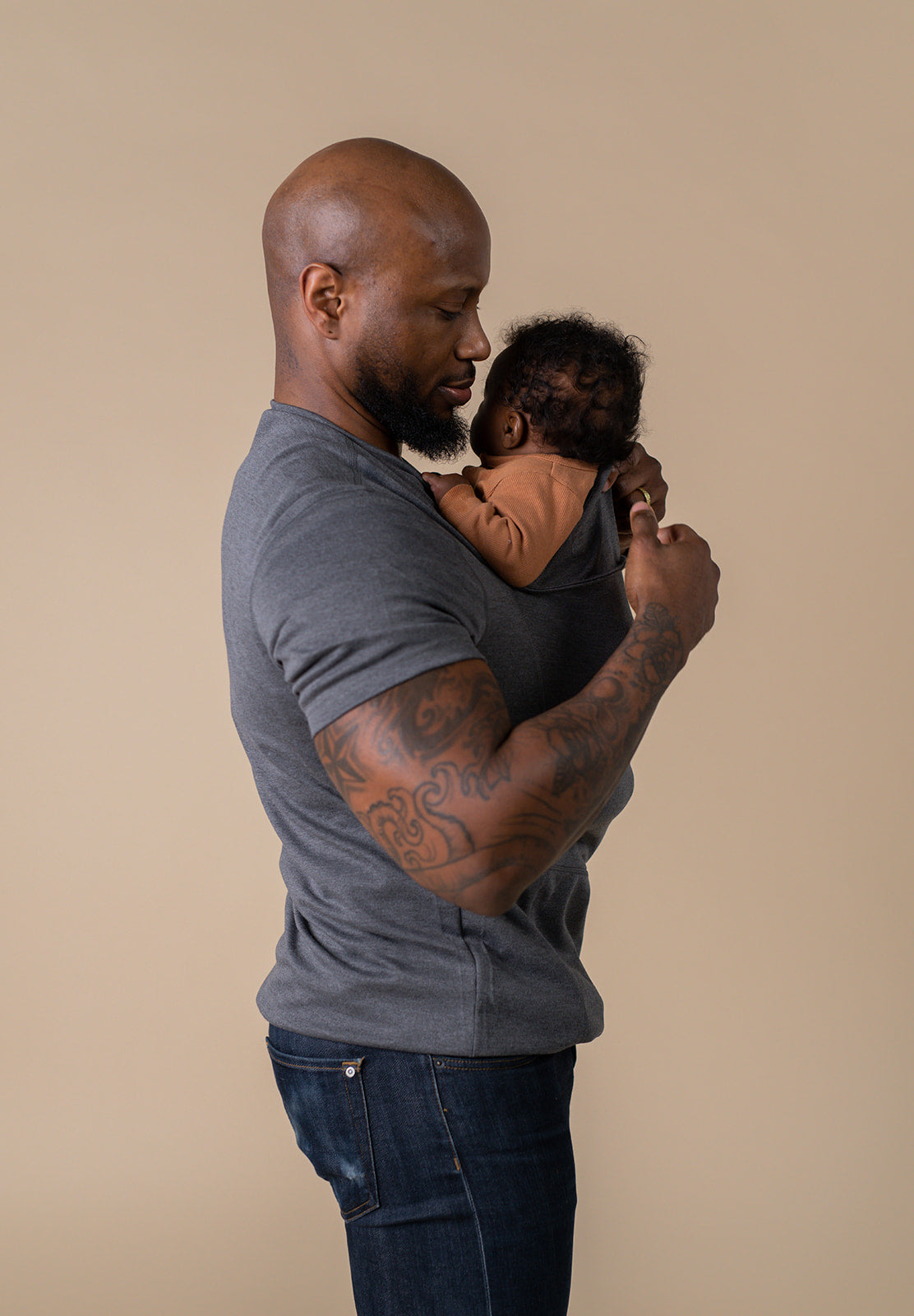 Dad adjusting the pouch around baby.