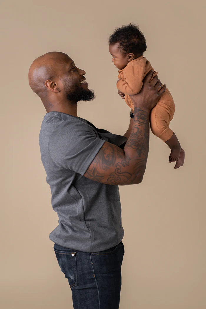 Dad holding baby after removing from pouch.