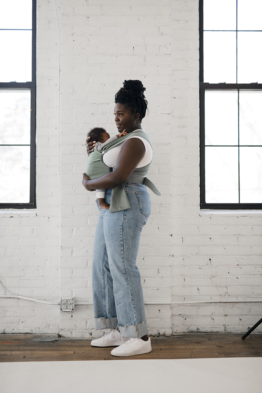 Female front carrying a baby in an Olive Simple Wrap.