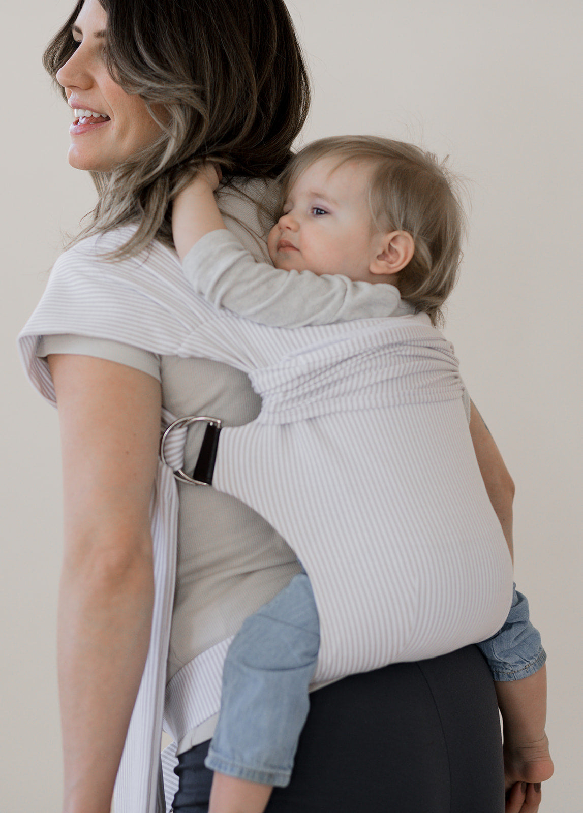Toddler being back carried in an Oatmeal Stripe Simple Wrap.