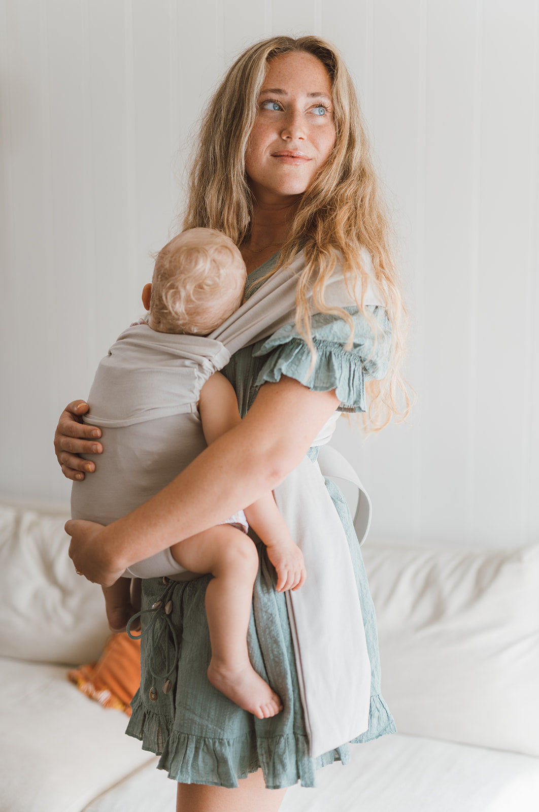 Female front carrying a baby in a Flax Simple Wrap.