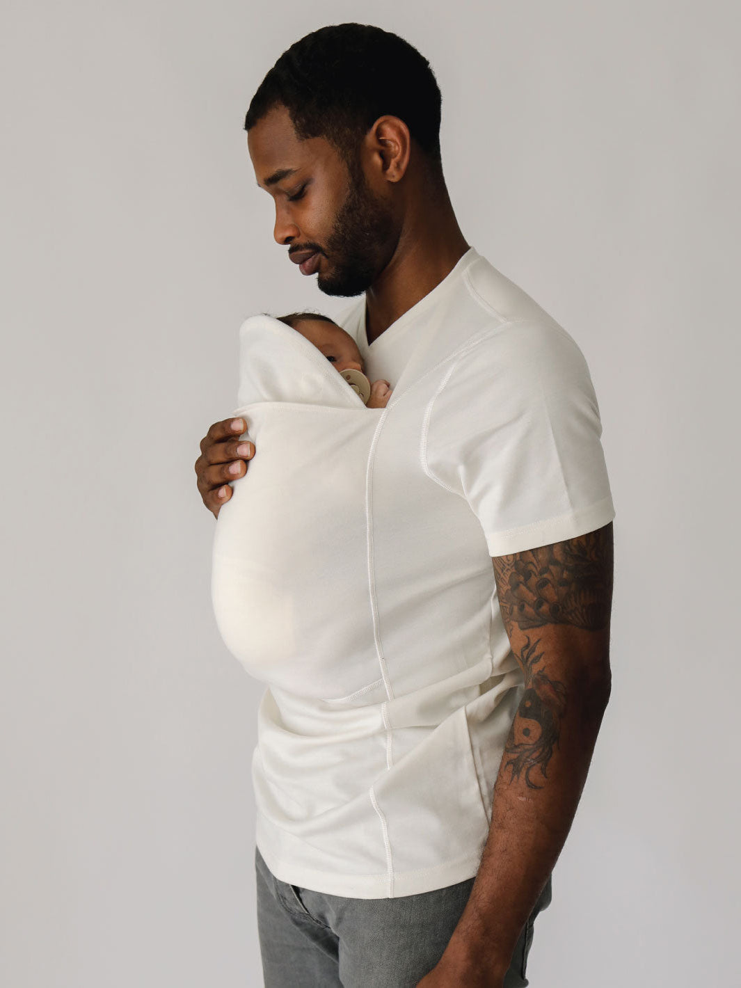 Male wearing a newborn in a Natural Dad Shirt with pouch extender pulled up.