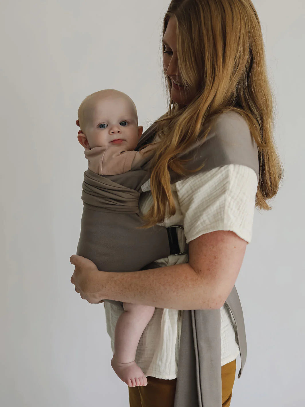 Female front carrying a baby in a Driftwood Simple Wrap.