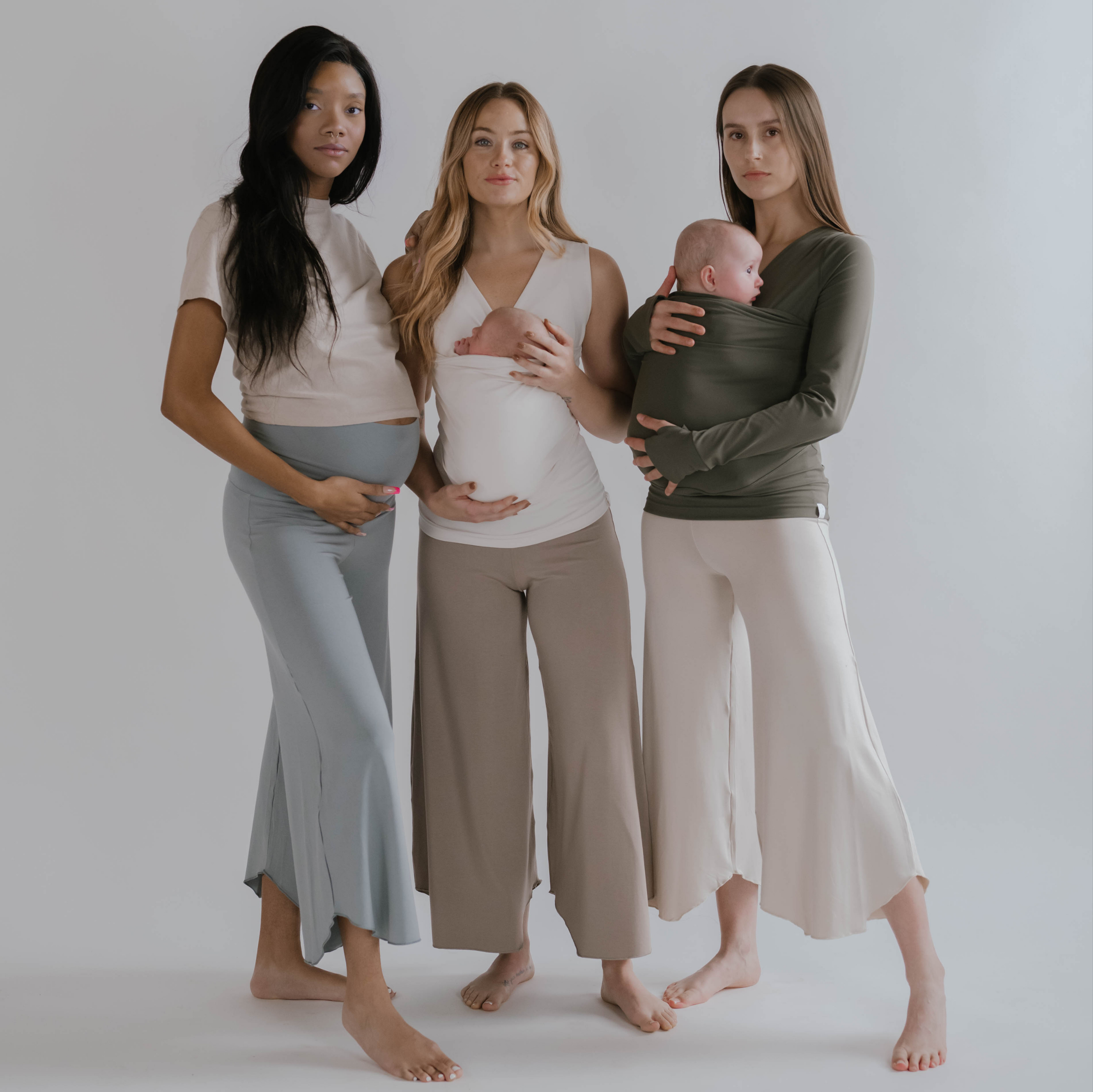 3 moms wearing flow pants, 1 pregnant and 2 with newborns in Soothe Shirts.