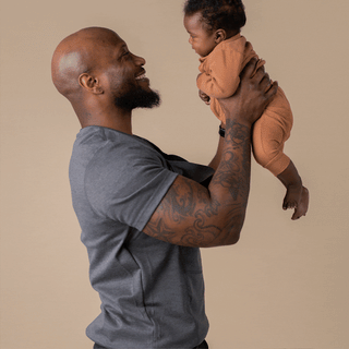Rotating images of a Dad putting a baby in the Dad Shirt.