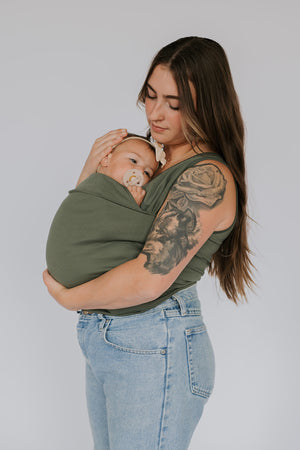 Side view of a female wearing a newborn in a Fern Soothe Shirt.