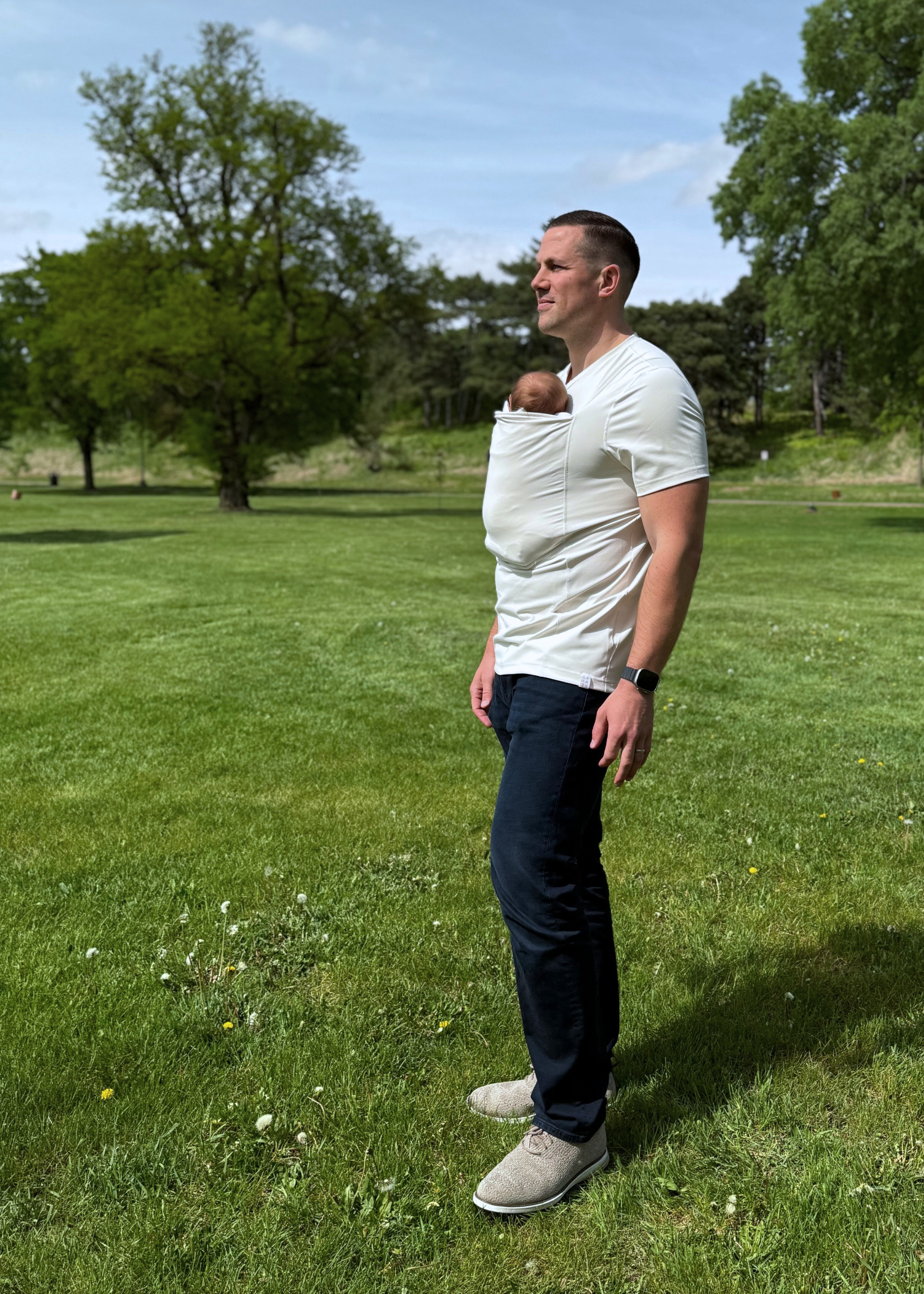 Full body side view of a dad wearing a newborn in the pouch of his Natural Dad Shirt.