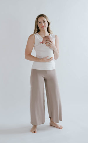 Mom wearing a newborn in a natural Soothe Shirt with Driftwood Flow Pants.