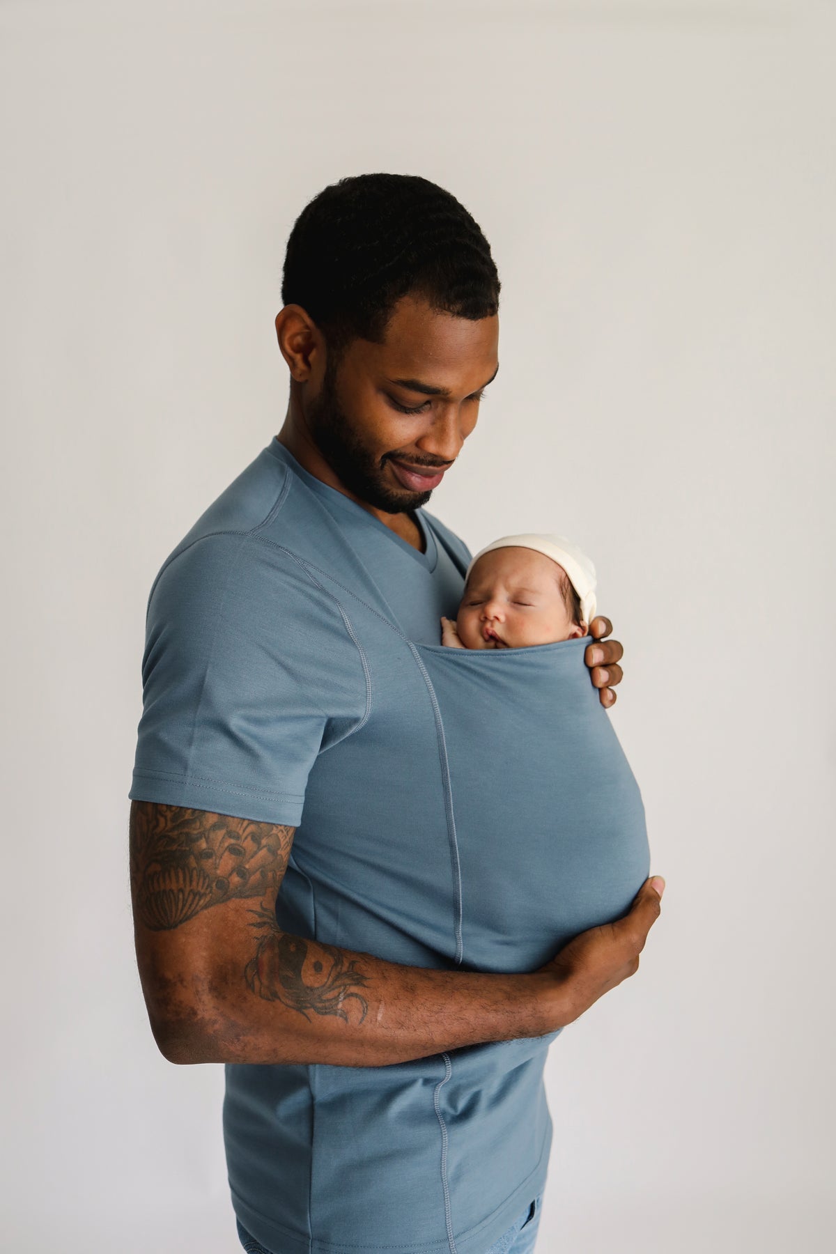 Side profile of a dad wearing a newborn in a Brook Dad Shirt.