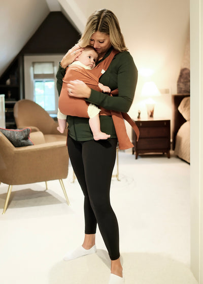 Mom snuggling the baby she's front carrying in a Clay Simple Wrap in her bedroom.