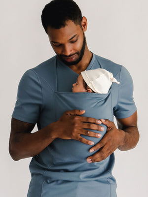 Front view of a dad wearing a newborn in a Brook Dad Shirt.