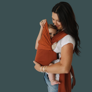 Side profile of a mom front carrying a baby in a clay simple wrap.