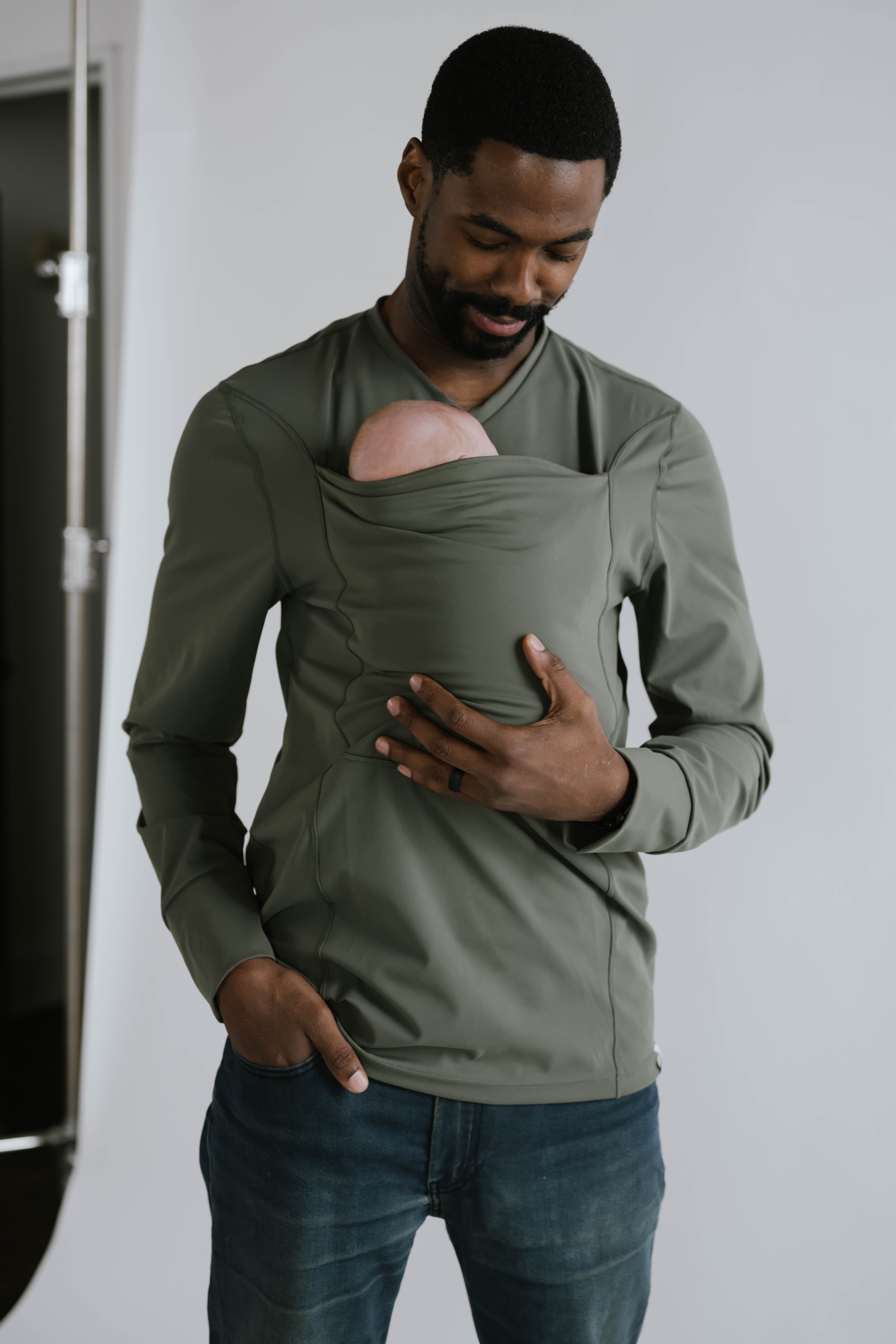 Dad looking at the newborn in the pouch of his Fern long sleeve Dad Shirt.