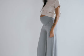 Pregnant mom showing the high rise and comfy fit of Flow Pants over her bump.