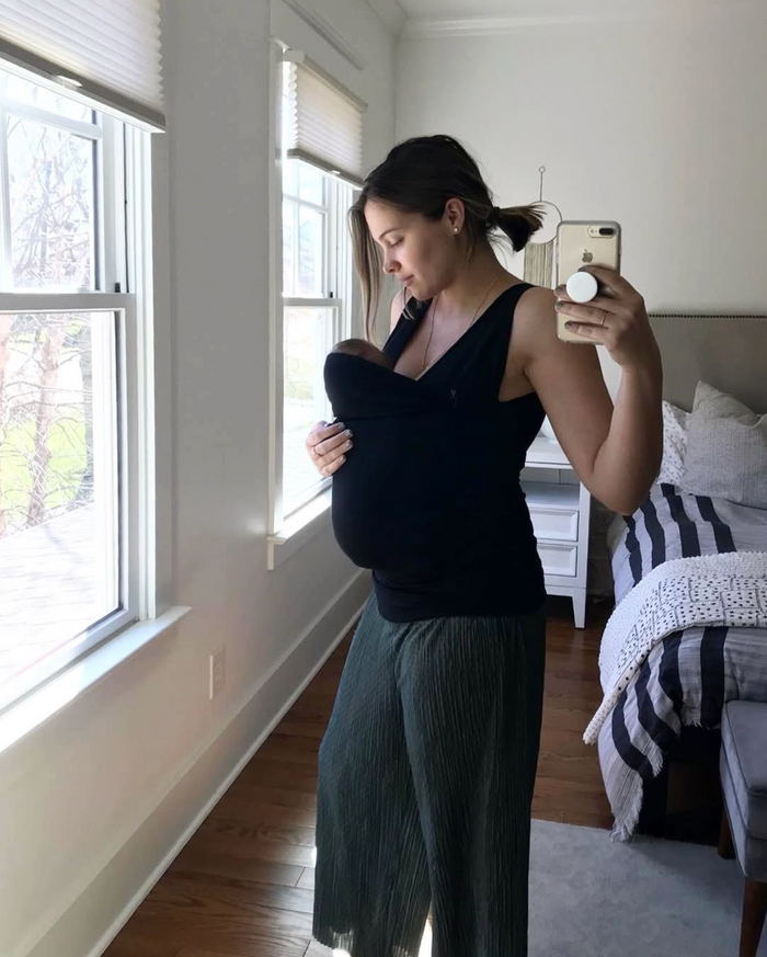 Mom wearing her newborn in a Mom Shirt at home