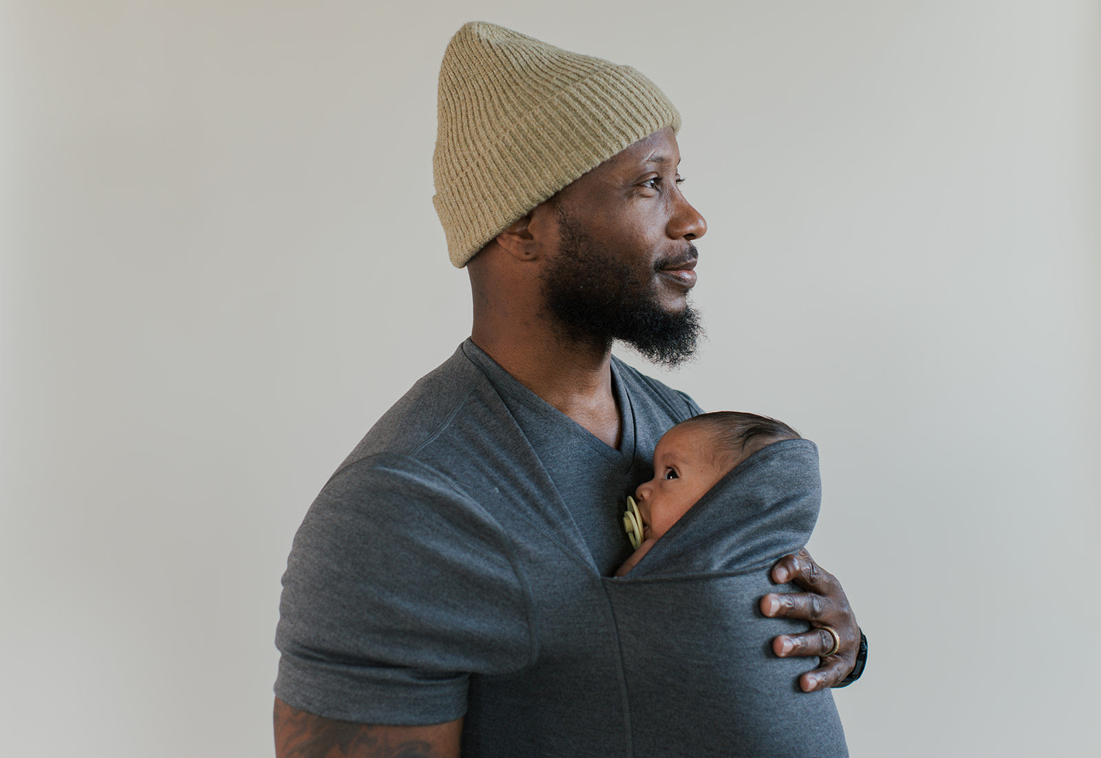 Side profile of a dad wearing a newborn in a gray Dad Shirt.