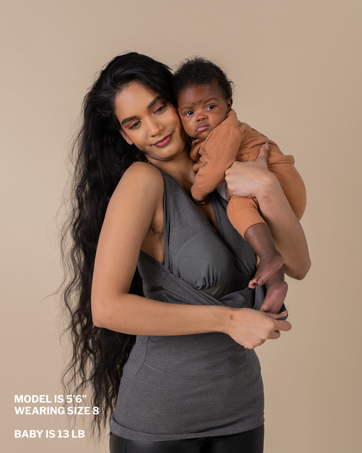 Mom putting baby in the soothe shirt pouch.  "Model is 5 ft 6 in, wearing size 8, baby is 13 lbs"