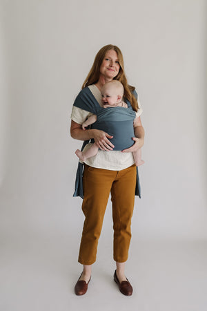 Full view of a mom front carrying a baby in a simple wrap.