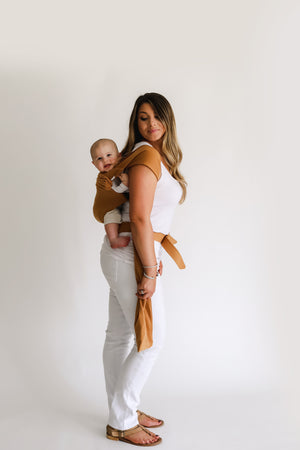 Female back carrying a baby in a Camel Simple Wrap