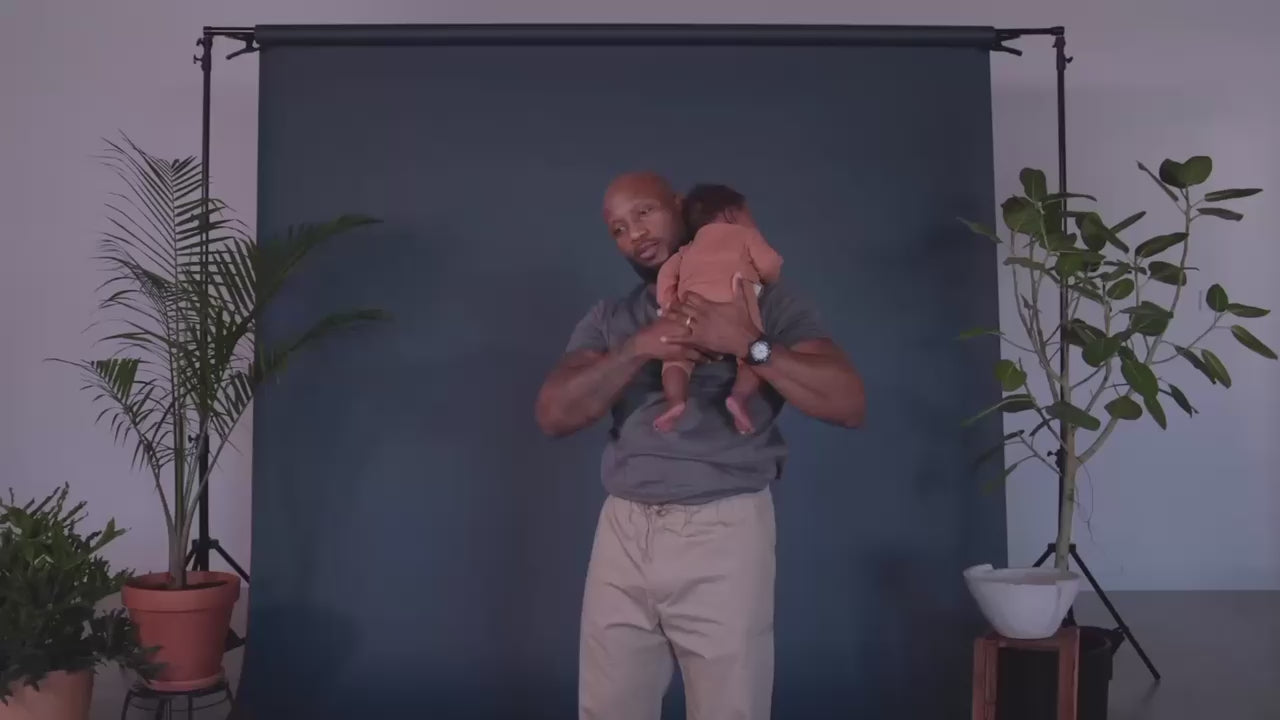 Dad demonstrating how to open the pouch of a Dad Shirt and slide baby into it.