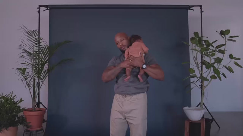 Dad demonstrating how to open the pouch of a Dad Shirt and slide baby into it.