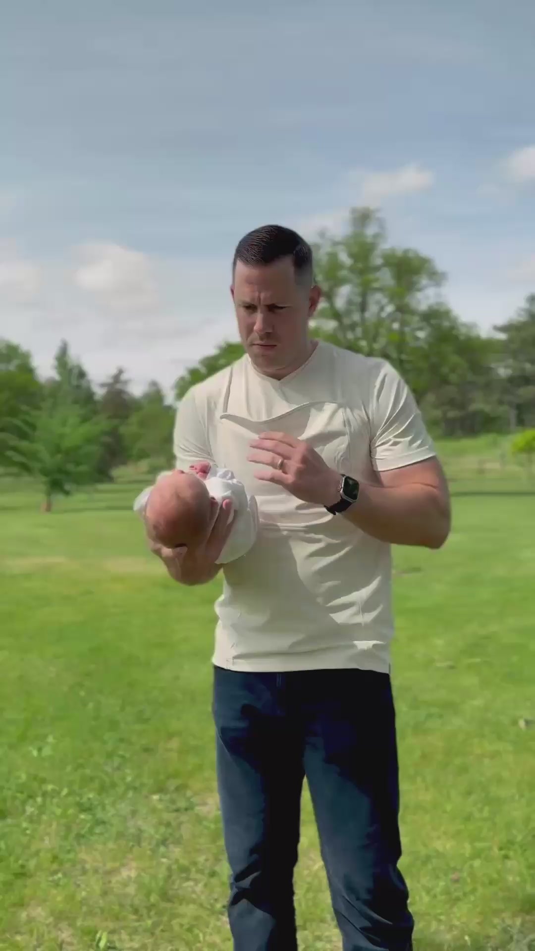 Load video: A dad opens the pouch of his natural Dad Shirt, slides his newborn in and goes for a stroll.