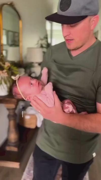 A dad easily slides his daughter into the pouch of his Dad Shirt.