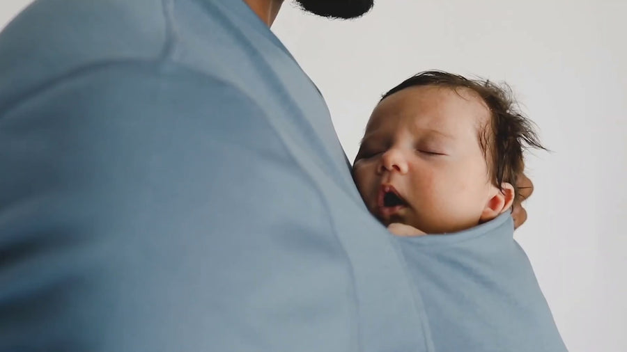 Dad snuggling the baby inside the pouch of his brook Dad Shirt. 