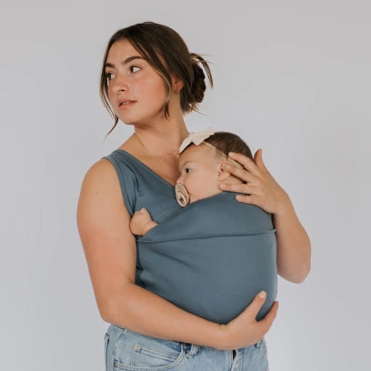 Mom looking to the left with a baby in a blue Soothe Shirt