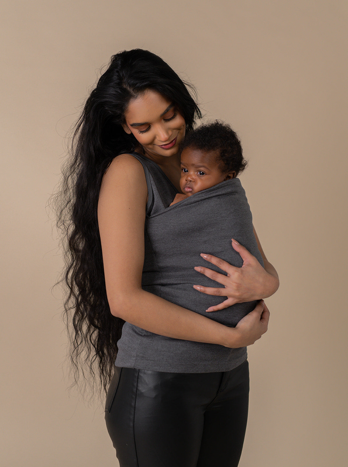 Female snuggling a newborn in a gray Soothe Shirt.