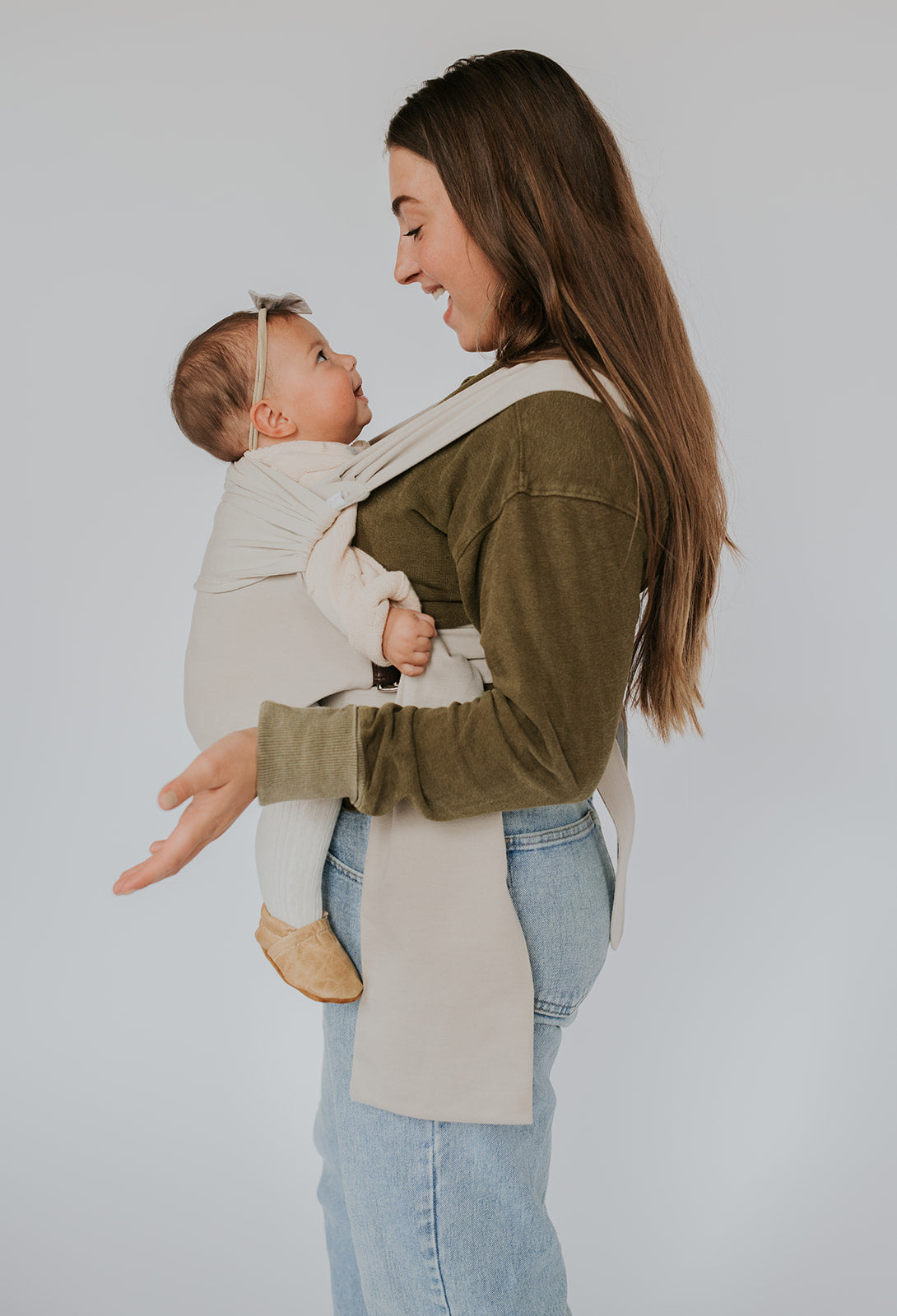 Female front carrying a baby in a Flax Simple Wrap.