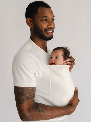 Male wearing a newborn in a Natural Dad Shirt.