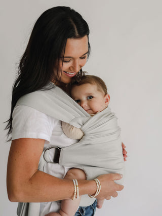 Side view of a female front carrying a baby in a Fog Simple Wrap.