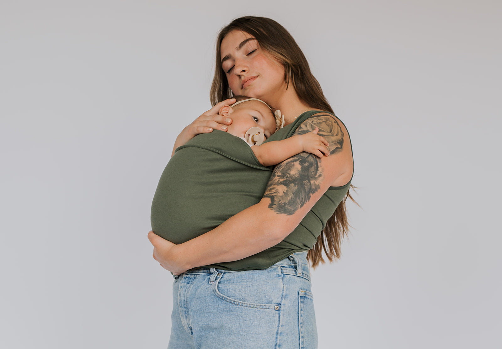 Female snuggling a newborn in a Fern Soothe Shirt.