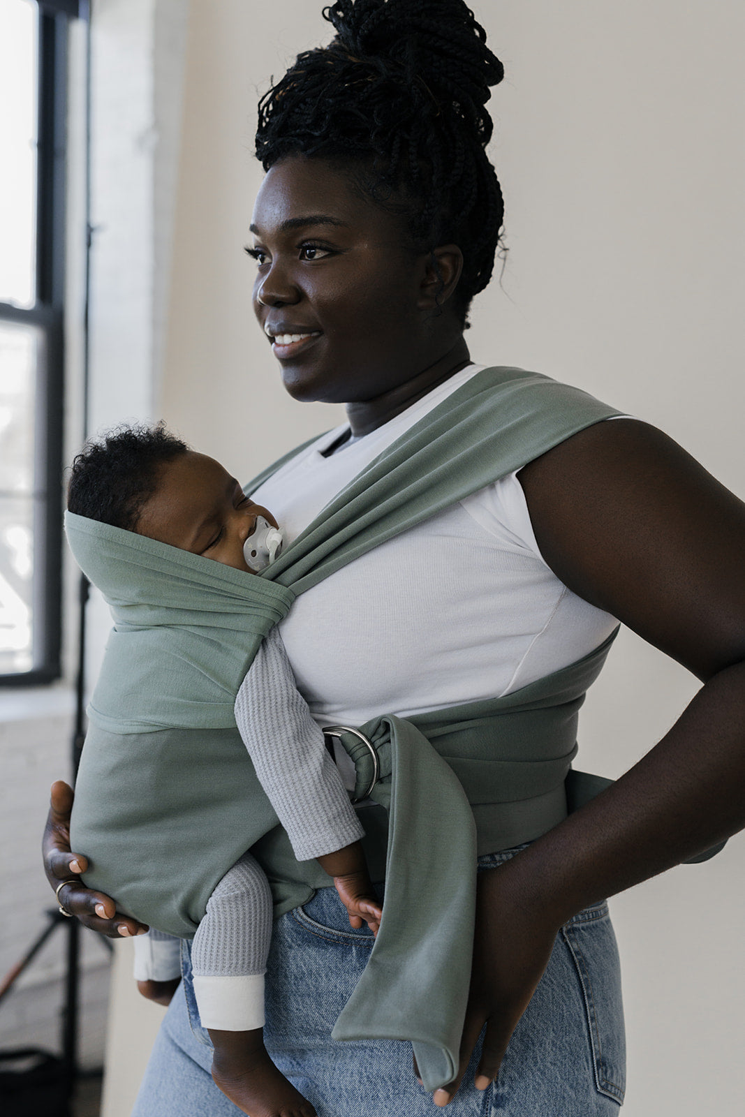 Angled profile of a mom wearing her sleeping baby in an Olive Simple Wrap.