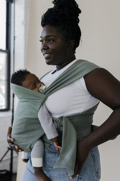 Angled profile of a mom wearing her sleeping baby in an Olive Simple Wrap.